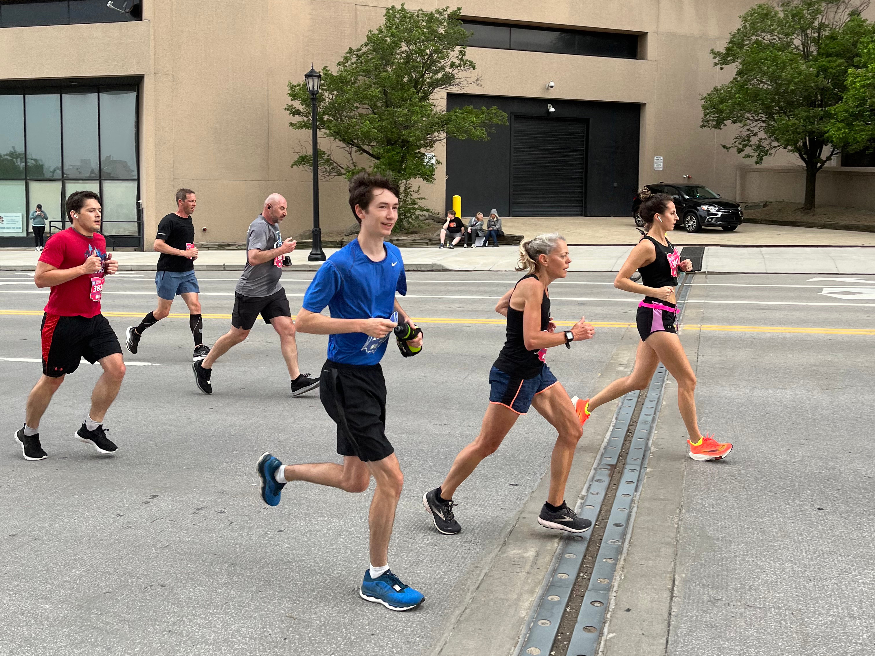 Me, running in a blue shirt and carrying a yellow water bottle. I'm smiling. There are other runners around me.
