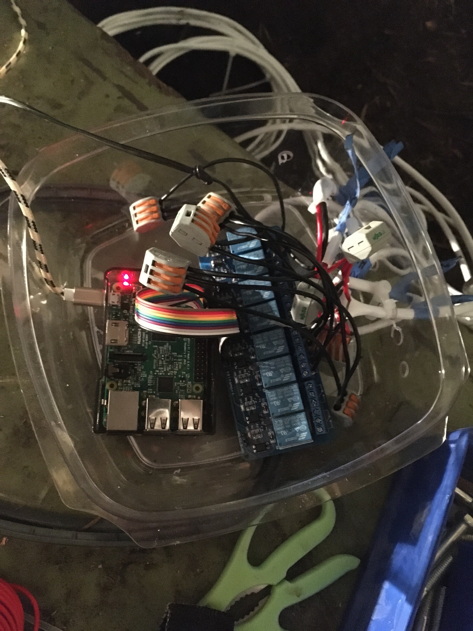 A plastic tub containing the Raspberry Pi, relay board, and a mess of wires