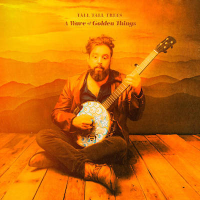 Album art for A Wave of Golden Things: Tall Tall Trees sits on the floor holding his colorful banjo. Everything is bathed in orange.